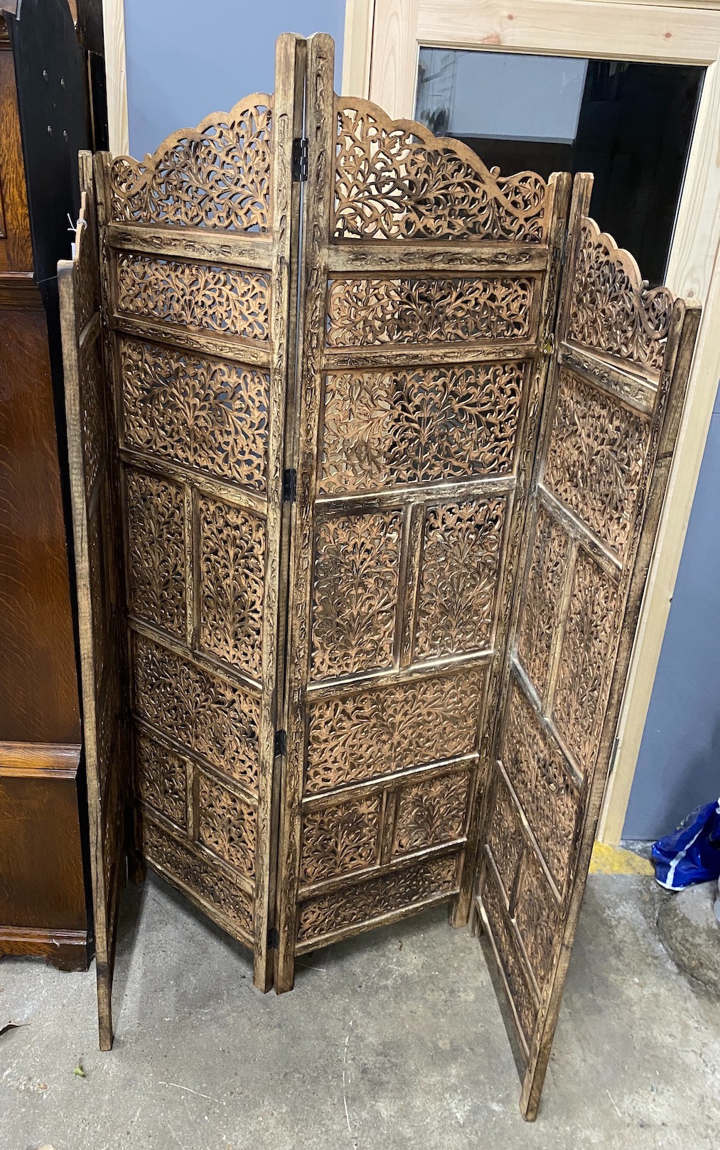 An Indian carved hardwood four fold screen, largest panel width 50cm, height 184cm